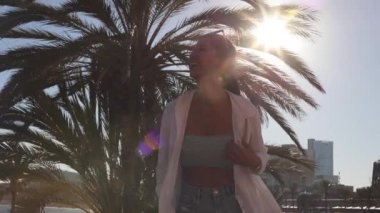 pretty asian woman on the beach next to a palm tree