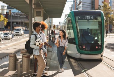 group of students at the train stop to go to university. concept of electric transport, subway, tram.