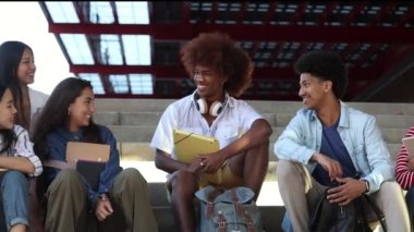 video of diverse students sitting on the stairs while talking and having fun. slow motion