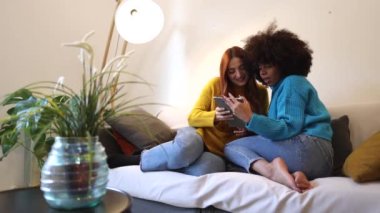 Lesbian couple at home make selfie with digital tablet - Multiracial women make couple life.