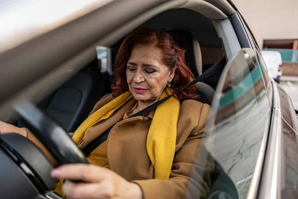 senior woman driving car sad