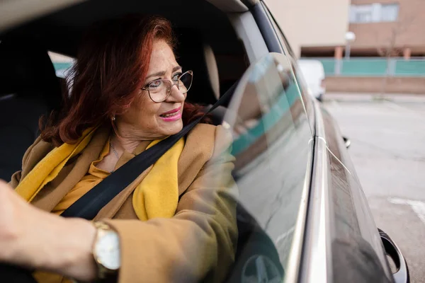 senior woman driving car with eyeglasses