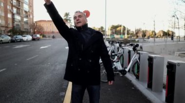 mature businessman on the street calling a taxi with his hand