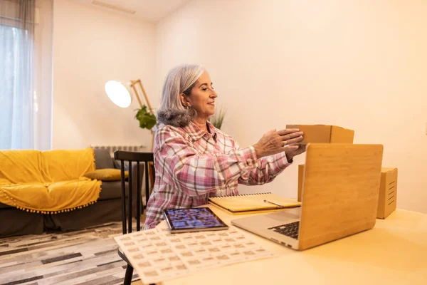 mature woman businesswoman works at home orders packages