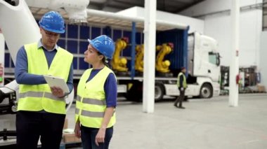 Robot şirketinde mühendislik işçileri. Teslimat ve mal dağıtımı için robotik silahlar yükleniyor