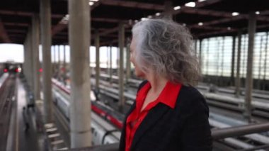 mature woman traveler walking by train station