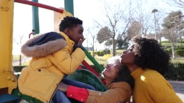 grandmother mom and grandson playing in the slide park - single mother, african american family -