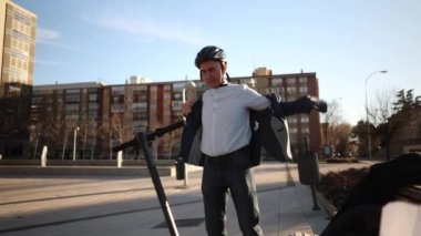 İş yerinden ayrılan işadamı, motosiklet elektriğine hazırlanıyor.