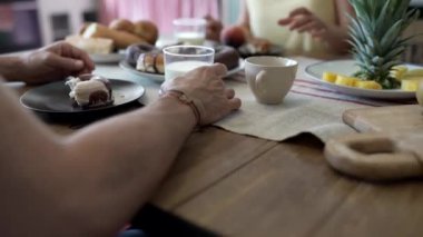 İnsanlar kahvaltı için mutfak masasına otururlar - yemekle masaya odaklanırlar. -