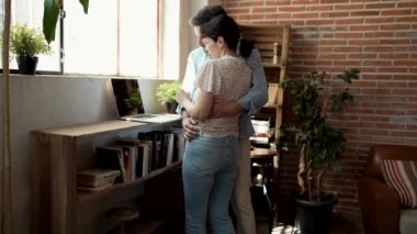 Evde dizüstü bilgisayara bakarken kucaklaşan olgun bir çift. Video görüşmesi konsepti, online alışveriş. -