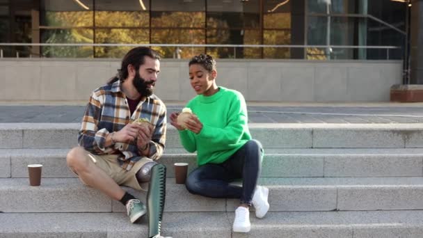 Pasangan Multirasial Makan Jalan Tangga Pria Dengan Kaki Prosthesis — Stok Video