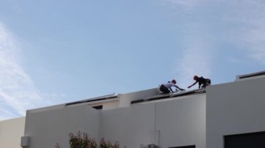 Bir evin çatısında işçiler güneş panelleri kuruyor yenilenebilir enerji-