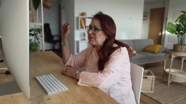 快乐成熟的60多岁女人挥手举行电脑视频会议 通过社交距离虚拟家庭在线聊天 坐在沙发上聊天 — 图库视频影像