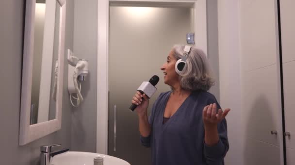 Ώριμη Ευτυχισμένη Γυναίκα Γκρίζα Μαλλιά Τραγουδώντας Στην Μπανιέρα Χρησιμοποιώντας Μικρόφωνο — Αρχείο Βίντεο