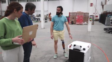 Nitelikli mühendislerden oluşan bir ekip, üretim verimliliğini artıran ve engelli bir adam da dahil olmak üzere işçilere iş olanakları sağlayan bir robot fabrikası tasarlayıp işletiyor..