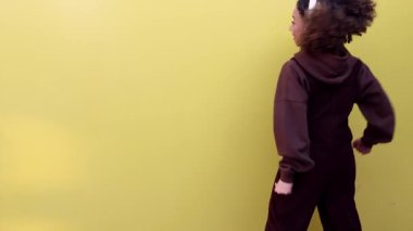 Kulaklıklar açık ve müzik açık, yetenekli bir Afro-Amerikalı kadın ritim tutar, tutku ve zarafetle dans eder..