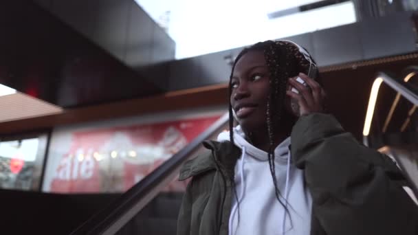Mujer Afroamericana Ropa Urbana Auriculares Ciudad Escaleras Mecánicas — Vídeos de Stock