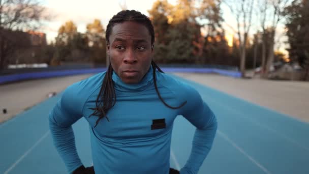 Afrikalı Sporcu Koşu Pistinde Dikilip Etrafa Bakıyor — Stok video