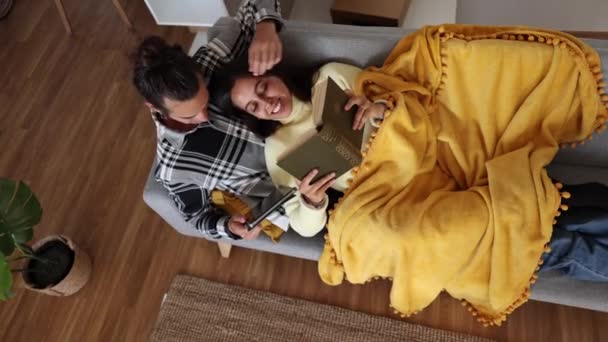 Heureux Jeune Couple Avec Tablette Réserver Sur Canapé Dans Salon — Video