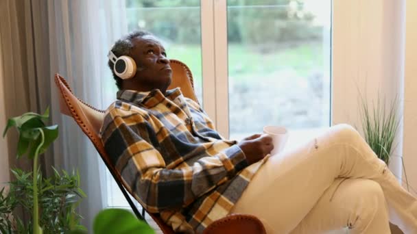 Uomo Anziano Africano Pensione Casa Utilizzando Cuffie Ascoltare Musica Mentre — Video Stock