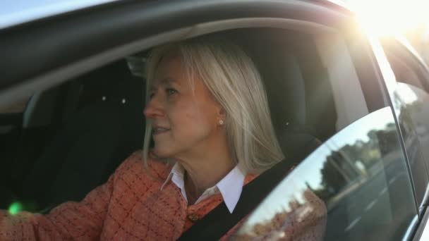 Mujer Mayor Conduciendo Atardecer Mirando Por Ventana Tráfico Feliz Dejando — Vídeos de Stock