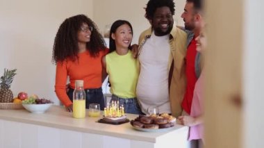 Bir grup çok ırklı arkadaş doğum gününü evde kutluyorlar.