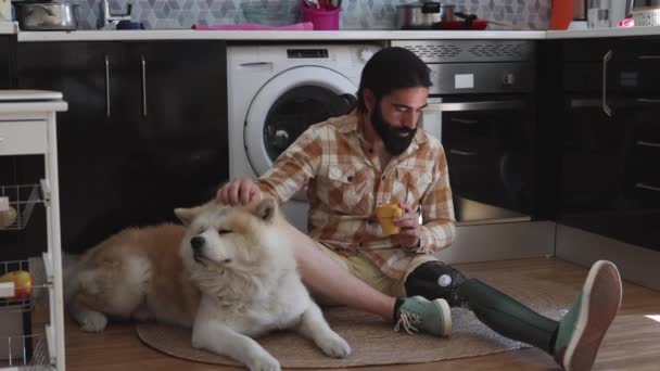 Pria Cacat Berjanggut Minum Kopi Samping Anjingnya Karpet Dapur — Stok Video
