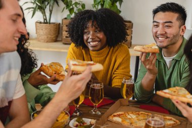Mutlu çok ırklı arkadaşlar evde pizza yiyorlar - milenyum arkadaşları birlikte hafta sonunun tadını çıkarıyorlar - Afro-Amerikan kadınlarına odaklan -