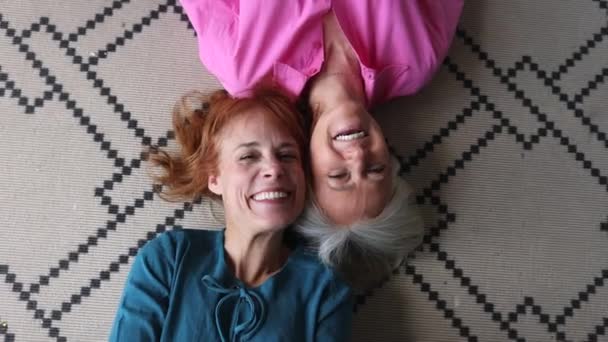 年长的女同性恋者 两个成熟的女人躺在地毯上 看着镜头 快乐的老女人夫妻 — 图库视频影像