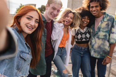 Şehirdeki genç öğrencilerin grup selfie 'si. Kızıl saçlı kadına odaklan. -