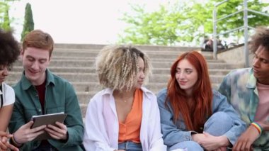 Öğrenciler bahçede çalışıyor, gençler birlikte zaman geçiriyorlar. Kitap okumak, dizüstü bilgisayarla çalışmak ve merdivenlerde otururken iletişim kurmak, çok ırklı bir grup.