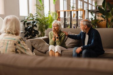 Yaşlı çiftler terapisi, psikoloji danışmanlığı tavsiye, yardım ya da destek için terapi. Yaşlı adam ve kadın psikologla, evlilik terapisi ve danışmanlık hizmetleriyle konuşuyor.
