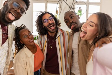 grup selfie insanları şaka yapıyor, çok ırklı iş arkadaşları kendilerini kaydediyor ve sosyal medya için akıllı telefonla fotoğraf çekiyor..