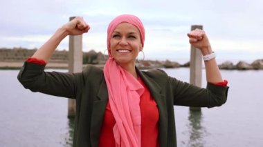 Şehirde mantra atkısı olan, göğüs kanseri farkındalığı olan güçlü olgun bir kadın, kanserden kurtulan bir savaşçı.