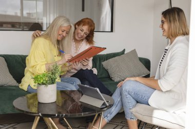 Mutlu, olgun bir çift banka kredisi anlaşması imzalamaya hazır borsacı, gülümseyen lezbiyen kadınlar. Kontrat sözleşmesi için yatırım yapmayı düşünün.