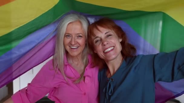 成熟した2人の女性が同性愛者の虹の旗を掲揚しています 私はLgbt 同性愛者 バイセクシャル レズビアン トランス 非バイナリコミュニティを支援しています 自由と権利のための戦い — ストック動画