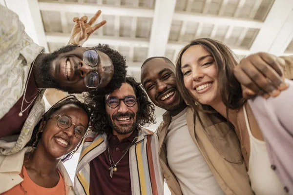 Group of happy friends posing for a selfie indoors, while having fun together, Group of multicultural friends having a good time together in the office, diverse students
