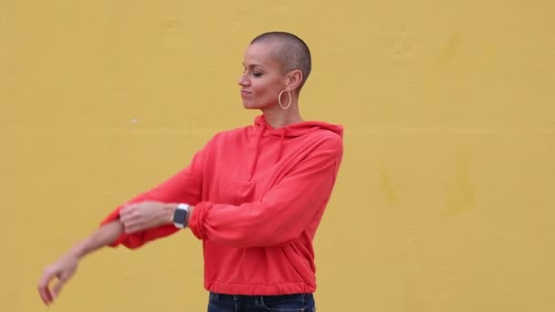 Зріла Жінка Поголеною Головою Силою Показує Сильну Руку Жовтий Фон — стокове відео