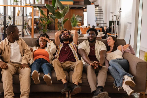 stock image group of coworkers in modern office cowoking, they have a hangover they are asleep waking up on the sofa