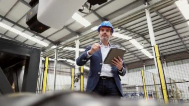 Yapım yöneticisi makine robot fabrikasını kontrol ediyor