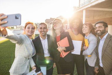 Fun, united colleagues taking a selfie with a phone looking excited, happy or motivated and ready to take startup business to the top. Smiling, happy and cheerful office group or team together