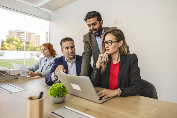 Ofisteki çok ırklı iş adamları bilgisayarlara, farklı nesillerden erkek ve kadınlara bakıyorlar.