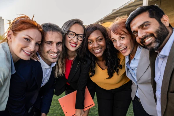 Happy excited diverse business team, mixed race employees of different generations taking selfie in office, holding mobile phone, looking at camera, smiling. Headshot portrait, screen view