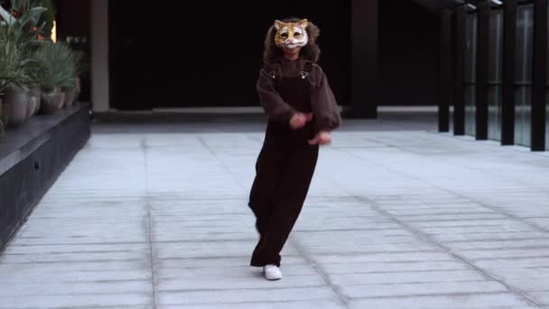 活気に満ちた都市服とタイガーマスクの女性 通りでヒップホップを踊る — ストック動画