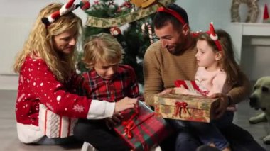Mutlu ve çocuklu bir aile Noel 'de evde hediyeleri birlikte açıyorlar.