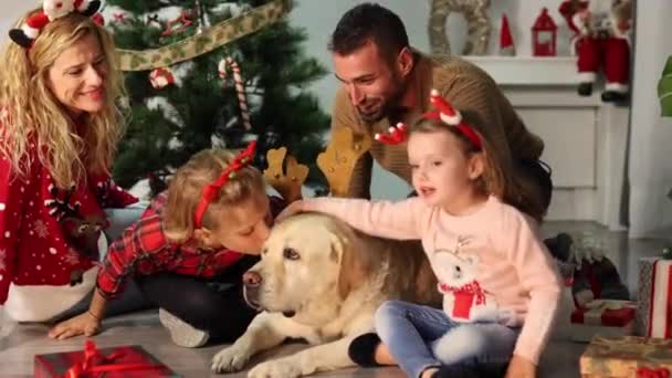 愛情を与える彼らの犬とクリスマスの幸せな家族 — ストック動画