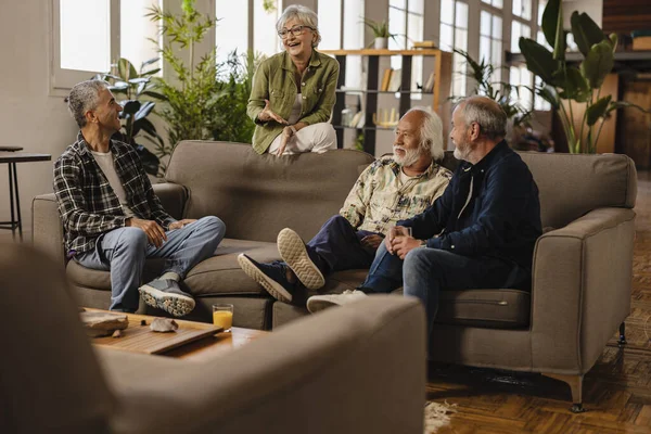 group of generational senior diverse friends meeting at home having fun - multiracial friends on sofa chatting -
