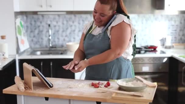 Podkręcone Kobieta Gotowanie Ciasto Domu Podczas Rozmowy Kimś Jej Smartfona — Wideo stockowe