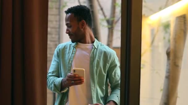 Genç Yakışıklı Afro Amerikan Milenyum Adamı Balkonda Akıllı Telefonuyla — Stok video