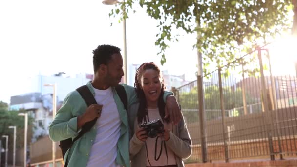 游客夫妇在城市观光游览 一个微笑的年轻游客和手里拿着相机 走在大街上 一起旅行的女人的画像 — 图库视频影像